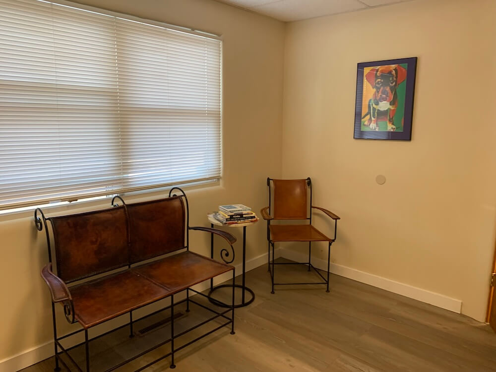 Warm dog-themed waiting room with seating and colorful canine artwork at a veterinary clinic in Santa Fe