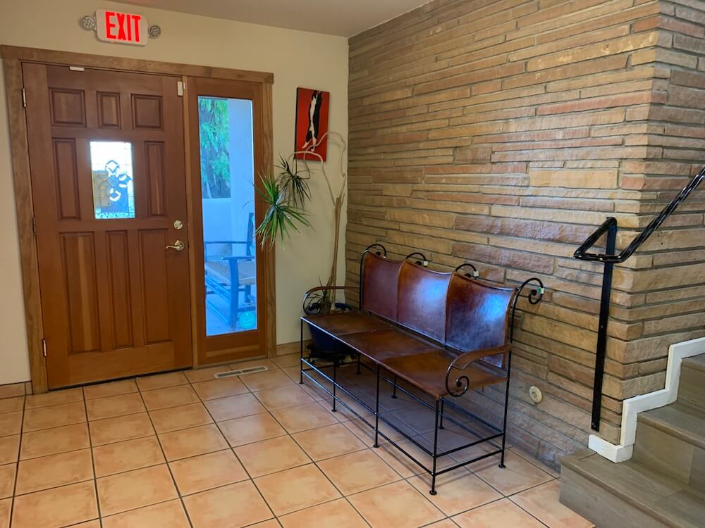 Welcoming front entrance of a veterinary clinic with brick wall and seating area in Santa Fe